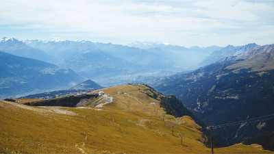 Le restaurant de Bellalui sur sa crête, avec la vallée du Rhône et les Alpes en arrière-plan