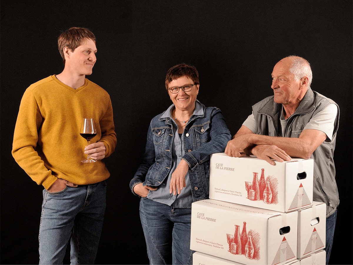 L'équipe de la cave de la Pierre, verre à la main, à côté de cartons de vin